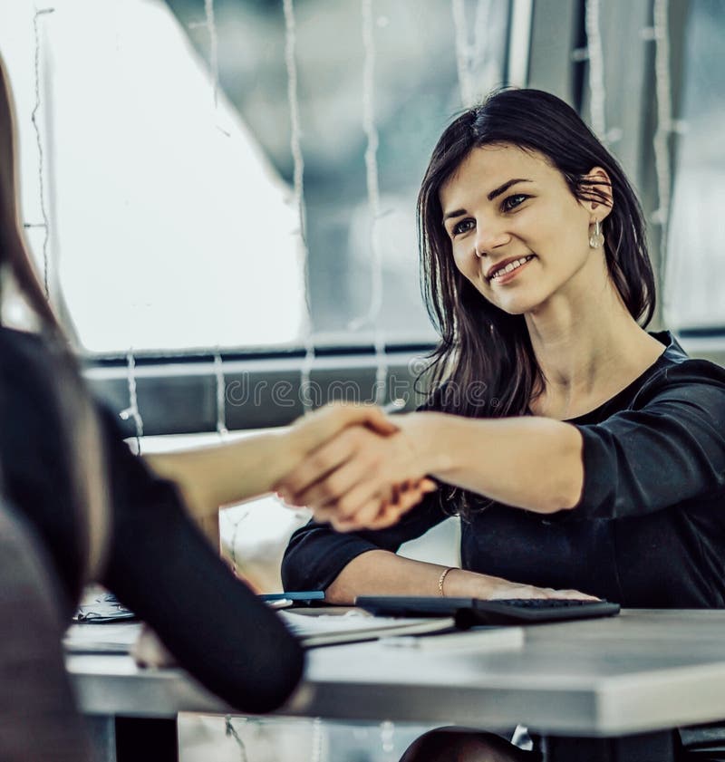 Two Businesswomen Shaking Hands In Modern Office stock image Two Businesswomen Shaking Hands In Modern Office stock image
