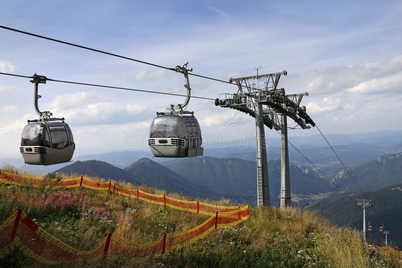 Two cable car cabins on the top of mountain