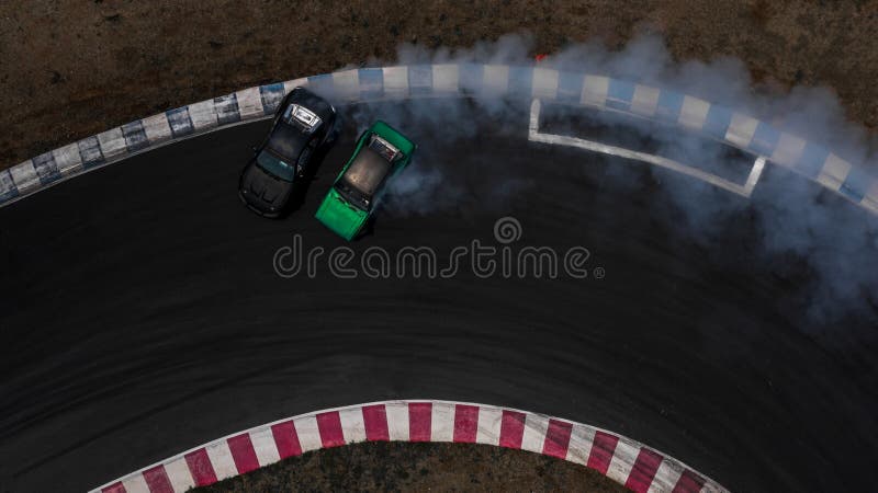 Two cars drifting battle on race track with smoke, Aerial view two car drifting battle