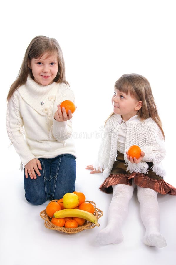 Two cheerful little girls with fruits