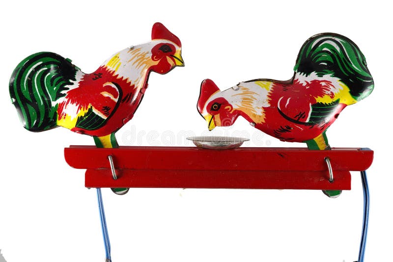 Two chickens peck grain from a plate, toy