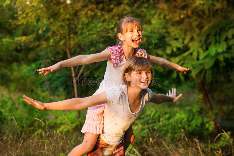 Two child girls playing together. Sisters play Superhero. Happy kids having fun, smiling and hugging.