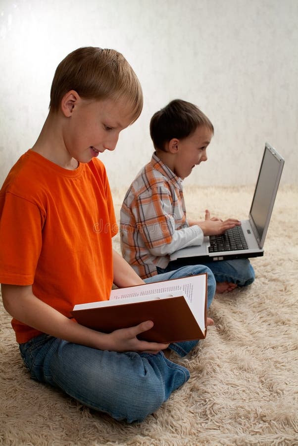 Two children with books and laptop