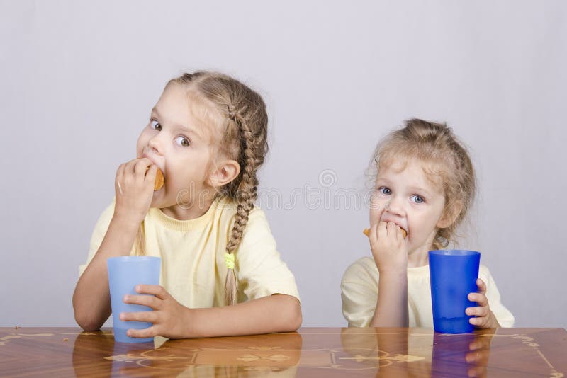 Two Children Eat a Muffin at the Table Stock Photo Image of food