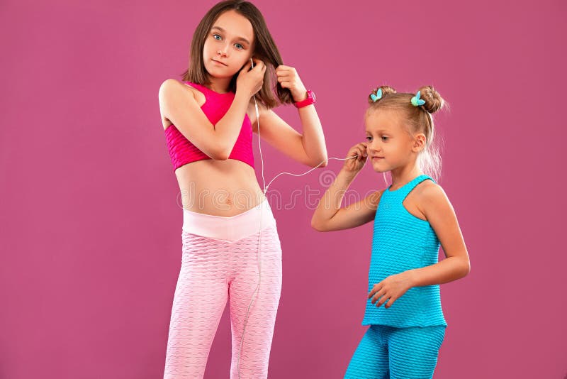 Two Children Girls Listen To Music on a Pink Background. Kids Lifestyle ...