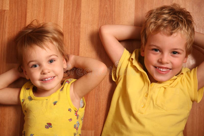 Two children lie on floor