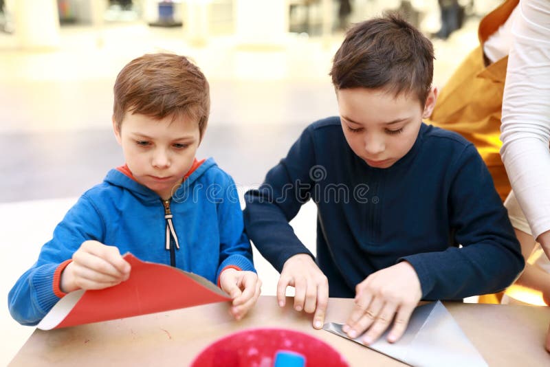 Two children make paper crafts stock photography