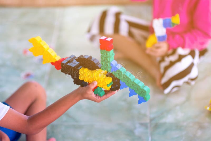 Two children playing with plastic jigsaw puzzles