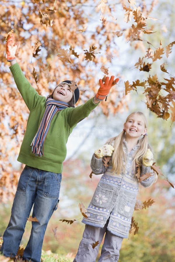 Two children throwing autumn leaves in the air. Two children throwing autumn leaves in the air