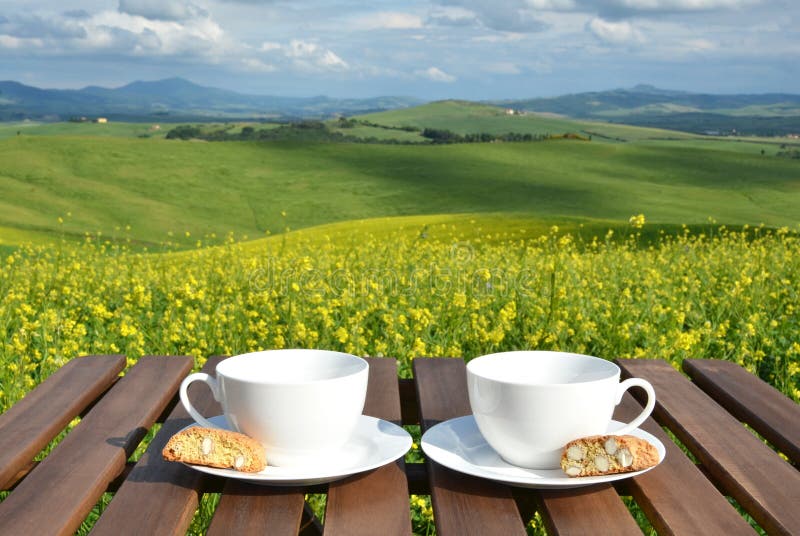 Two coffee cups and cantuccini on the wooden table