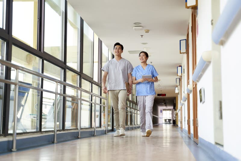 Two colleagues of nursing home walking in hallway