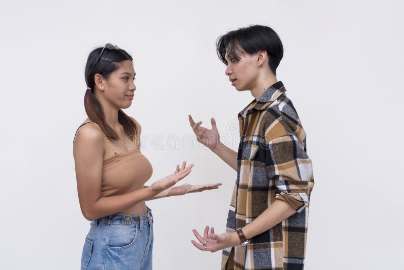 Two college students having a casual lighthearted conversation. One Filipina lady and one chinese guy. Isolated on a white royalty free stock images