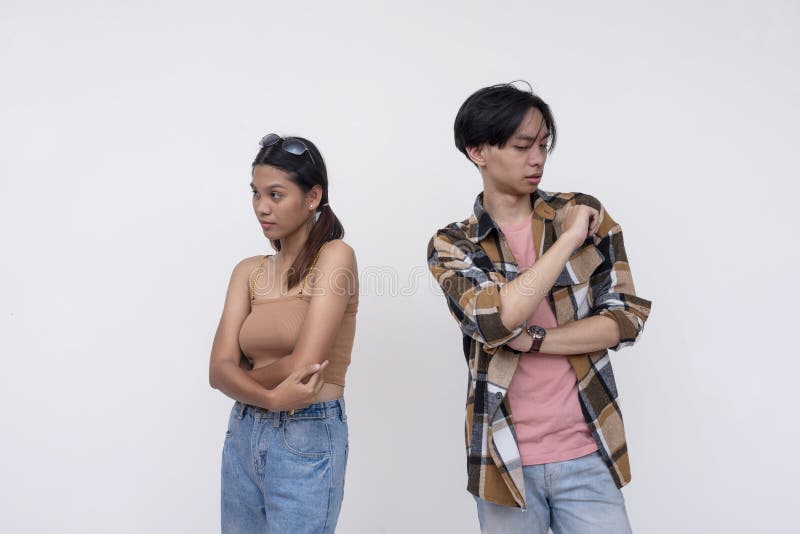 Two college students not on speaking terms, upset with each other. One Filipina lady and one chinese guy. stock photography
