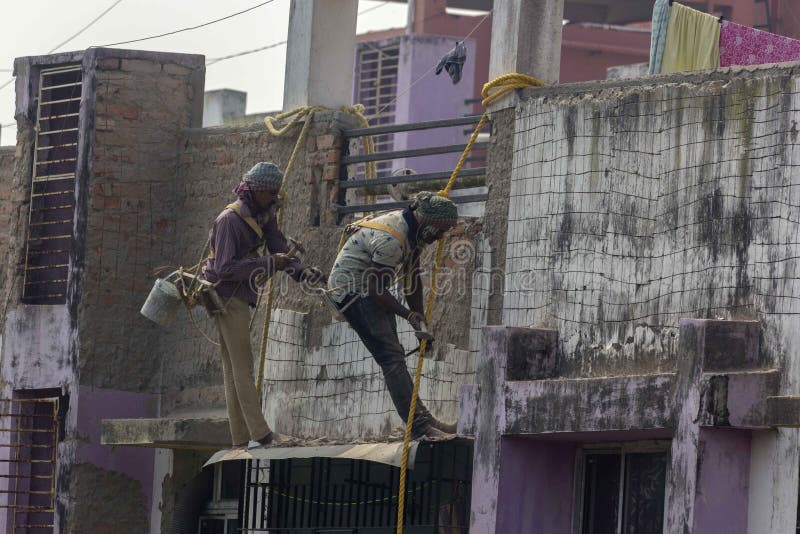 Two Construction Workers Doing Repair Work of Outer Wall while Hanging