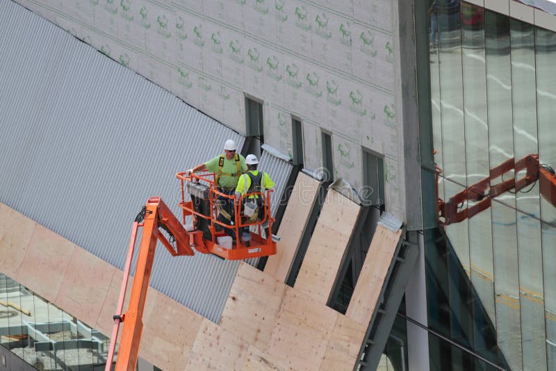 Two Construction Workers on Lift with Safety Vests Editorial Photo