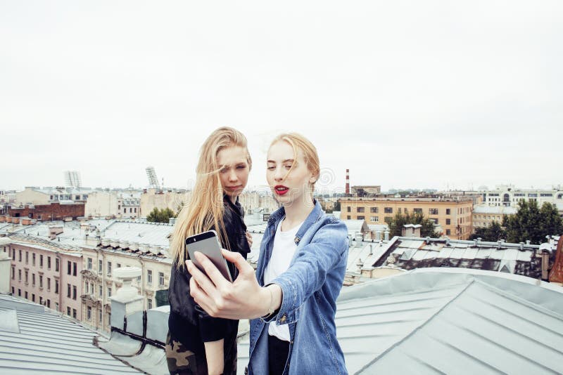 Two cool blond real girls friends making selfie on roof top, lifestyle people concept