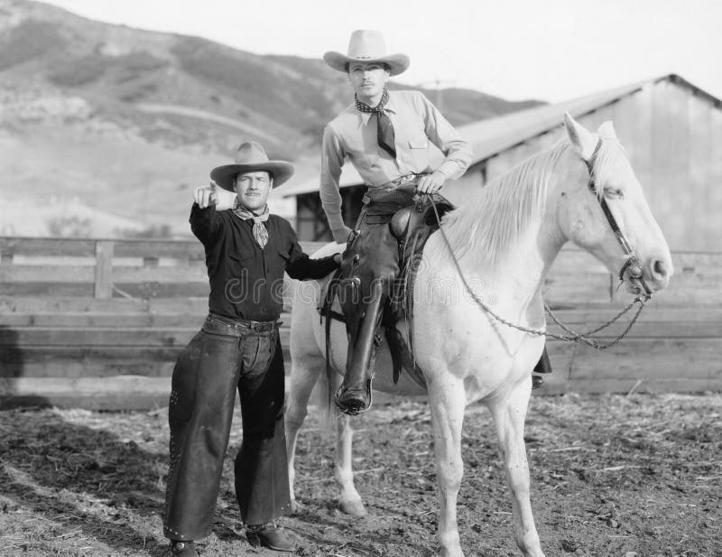 Two cowboys and a white horse