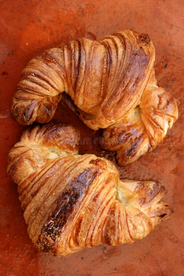 Two croissant pastries over orange clay