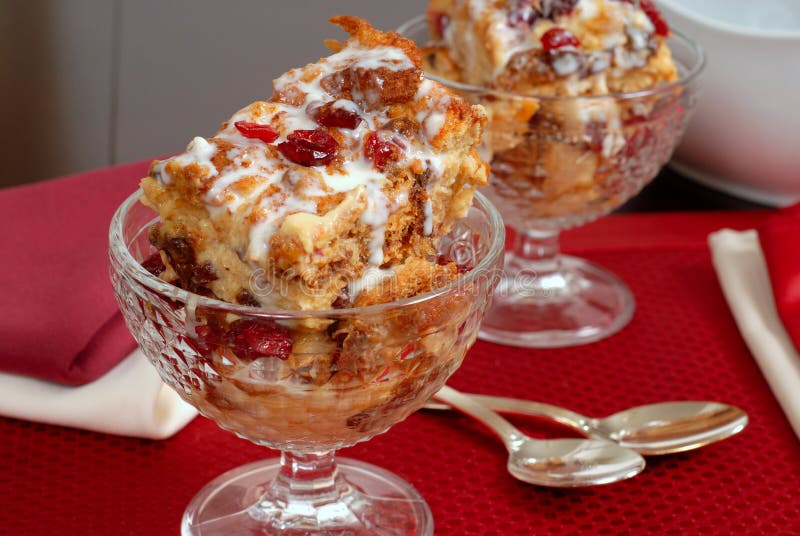 Two crystal goblets filled with Italian Panettone cranberry bread pudding with sauceboat in background stock photo Two crystal goblets filled with Italian Panettone cranberry bread pudding with sauceboat in background stock photo