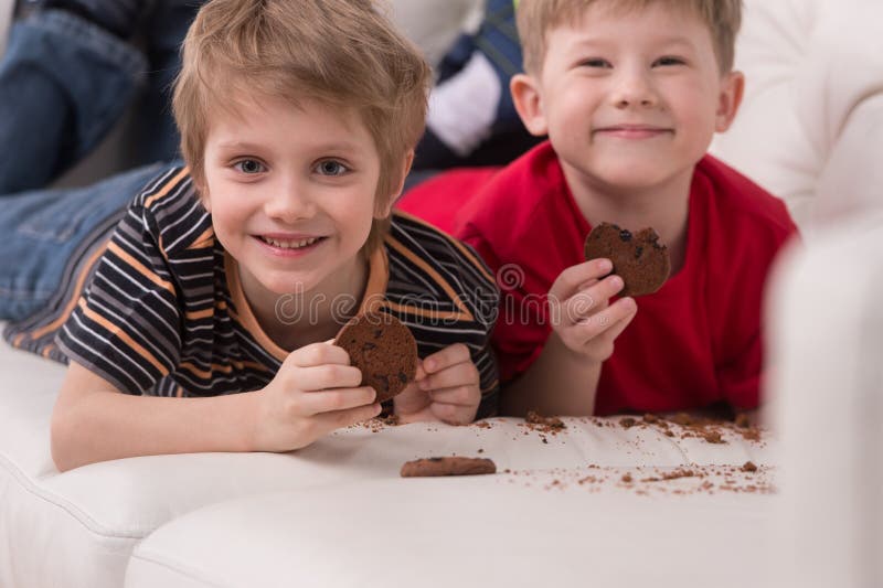 Two cute boys lying on couch. stock photos