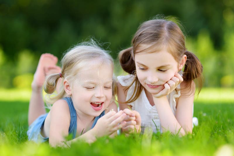 Two Cute Little Sisters Having Fun Together on the Grass Stock Photo ...