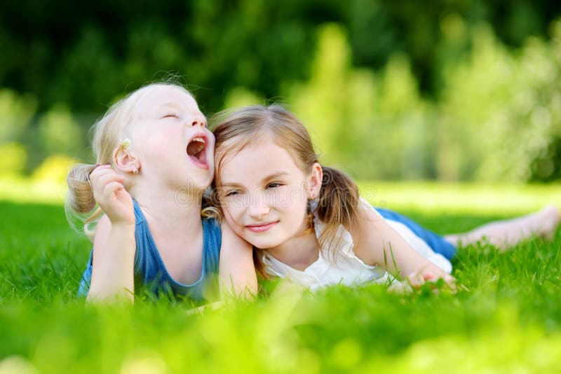 Two Cute Little Sisters Having Fun Together on the Grass Stock Image ...