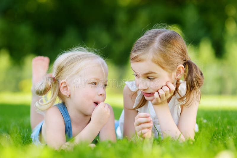 Two Cute Little Sisters Having Fun Together on the Grass Stock Photo ...