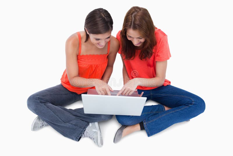 Two cute teenagers sitting cross-legged royalty free stock photography