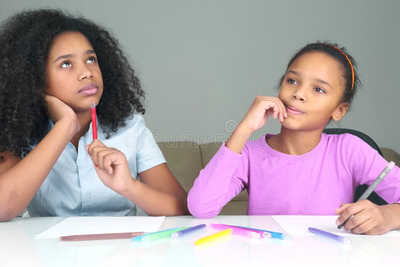 Two dark-skinned girls dream about the idea of drawing stock images Two dark-skinned girls dream about the idea of drawing stock images