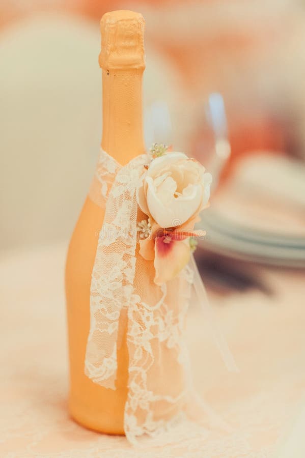 Two Decorated Bottles of Champagne and Brandy As Bride and Groom on