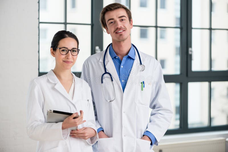 Two dedicated doctors smiling at camera