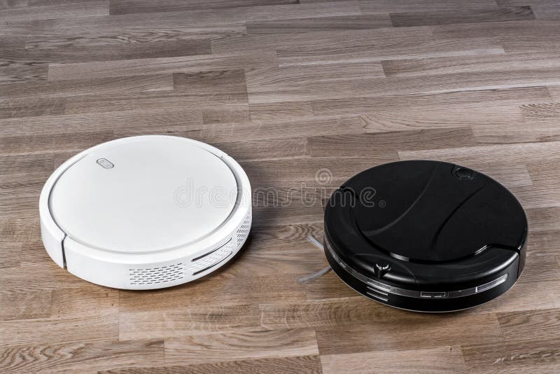 Two Different Robotic Vacuum Cleaners on Laminate Floor, Smart Home Robotics Wireless Cleaning