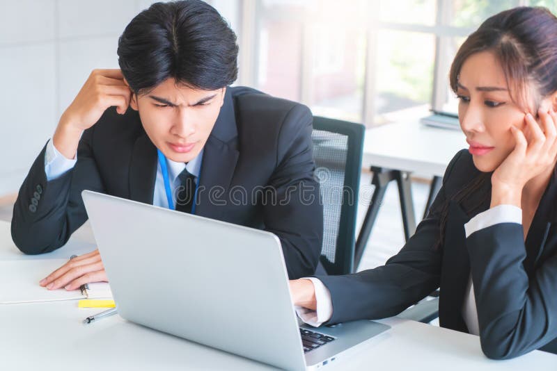 Two disappointed Business person looking at computer screen with upset and tired faces for business failure concept royalty free stock images