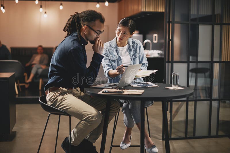 Two diverse young businesspeople working together at an office t stock image