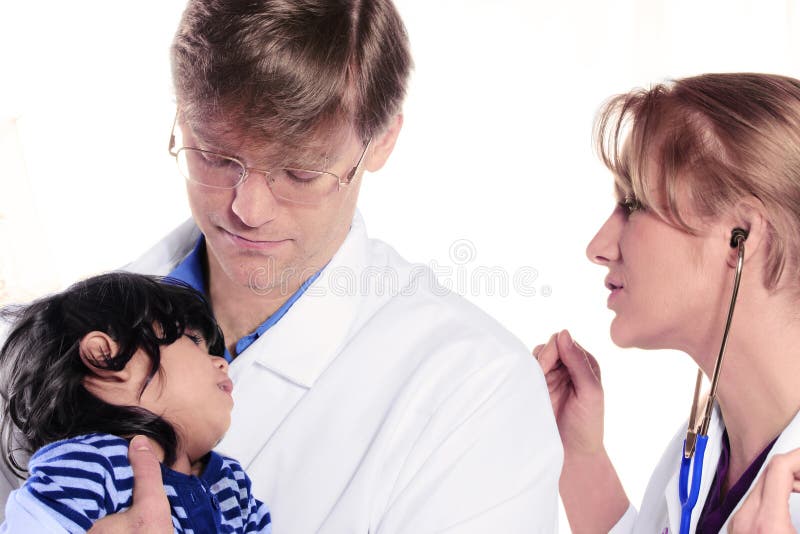 Two doctors caring for scared child patient