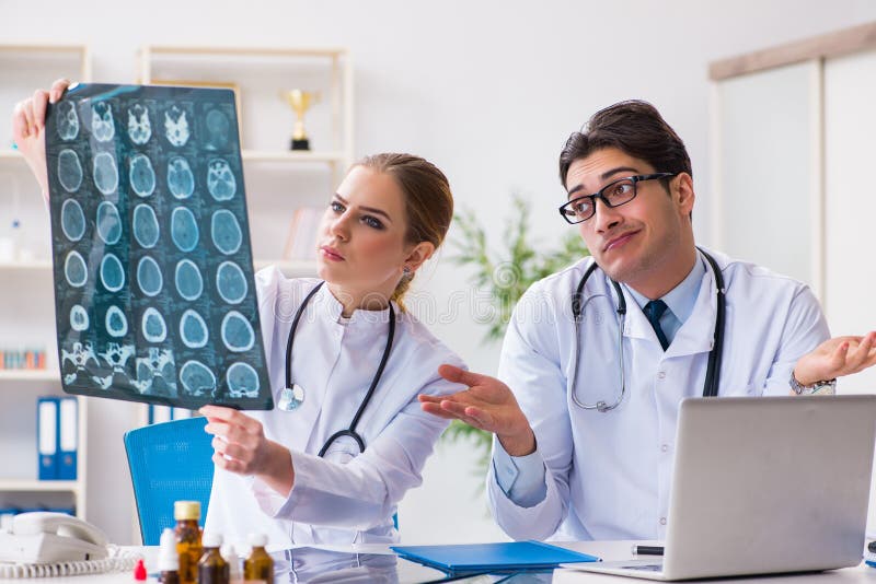 The two doctors examining x-ray images of patient for diagnosis royalty free stock photos The two doctors examining x-ray images of patient for diagnosis royalty free stock photos