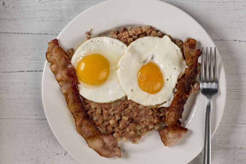 Two Eggs on Corn Beef Hash with a Side of Bacon Stock Photo Image of
