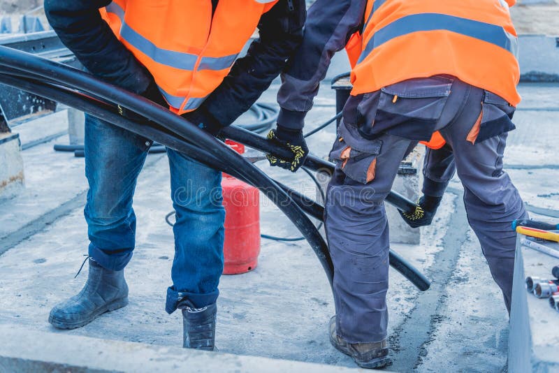 Two Electrician Builder Workers Installing Highvoltage Cable Stock