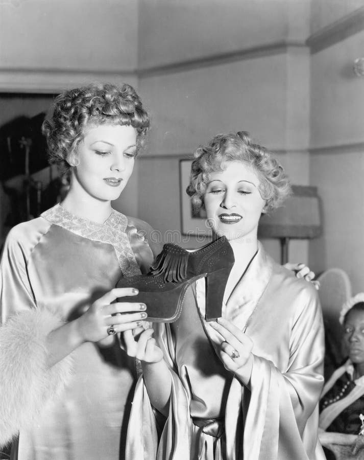Two elegant women looking at platform shoe. (All persons depicted are no longer living and no estate exists. Supplier grants that there will be no model release stock images Two elegant women looking at platform shoe. (All persons depicted are no longer living and no estate exists. Supplier grants that there will be no model release stock images