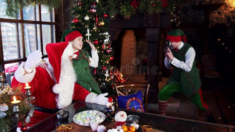 Two Elves and Santa Photographing on Christmas Background. Stock Footage - Video of night, elves: 163450330