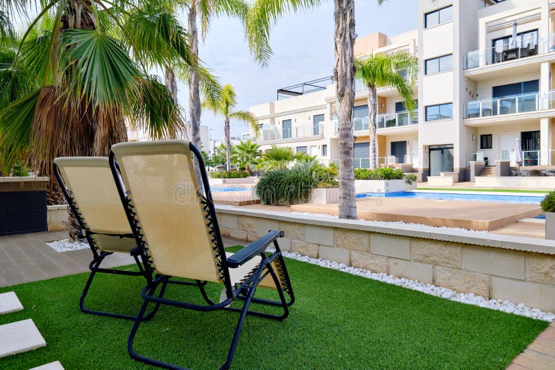 Two Empty Lounge Chairs on Artificial Lawn Grass Inside of Personal Area Backyard Residential 