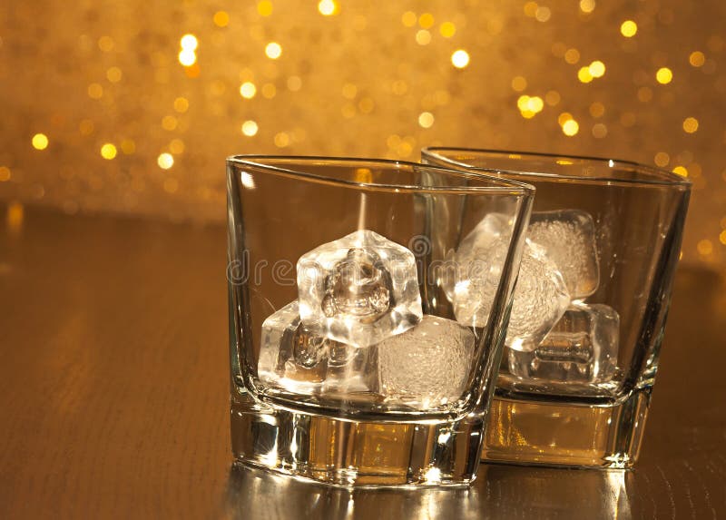 Two empty whiskey glasses on wood table and gold bokeh background. Bokeh whiskey stock images, royalty-free photos and pictures