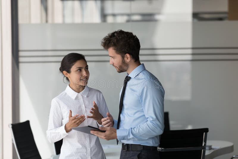 Two engaged diverse managers in formal clothed discussing business project