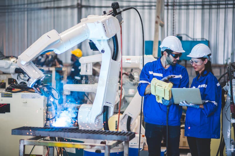 Two engineers mechanic using computer controller Robotic arm for welding steel in steel factory workshop. Industry robot stock photos