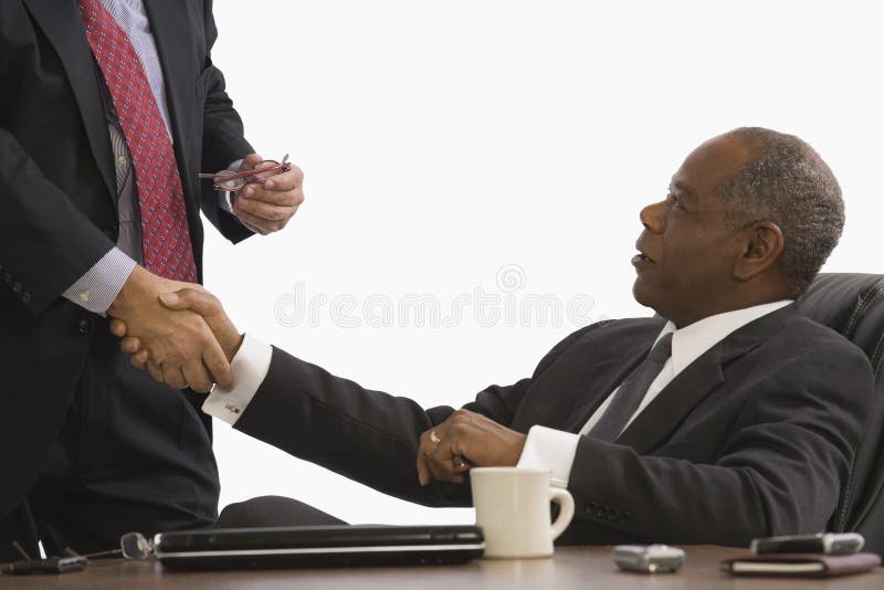 two businessmen shaking hands in an office