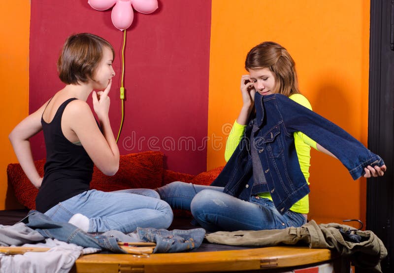 Two fashionable teenage girls choosing clothes