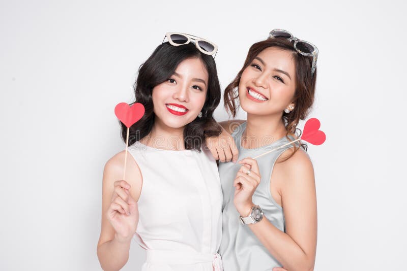 Two fashionable women in nice dresses standing together and hold stock images Two fashionable women in nice dresses standing together and hold stock images