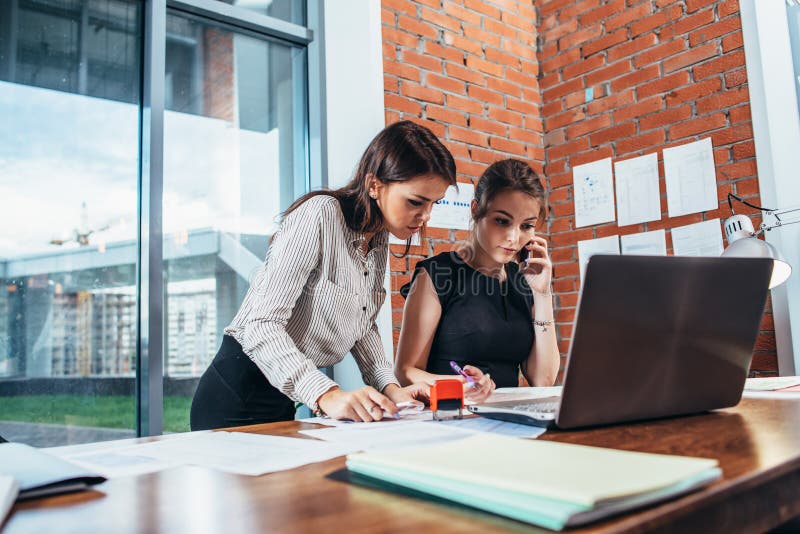 Two female colleagues in office working together. stock photo