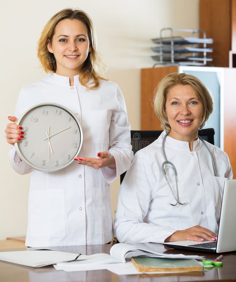 Two Female Doctors Showing Time in Clock Stock Image Image of clinic, posing 73367835