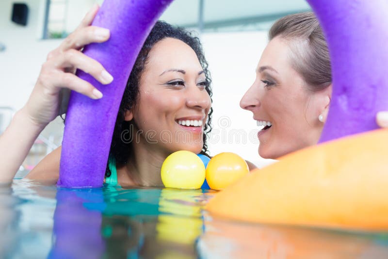 Two female friends attending swimming course stock photo Two female friends attending swimming course stock photo